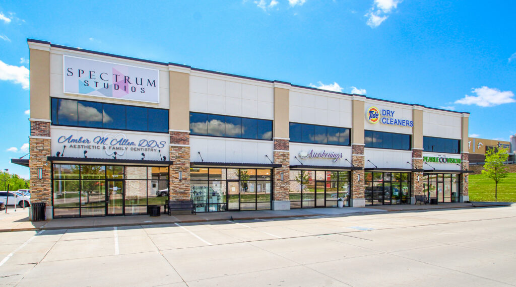 Front exterior of the commercial retail property at 3506 N 147th Street in Omaha, Nebraska, featuring multiple storefront suites, large windows, tenant signage, and surface parking